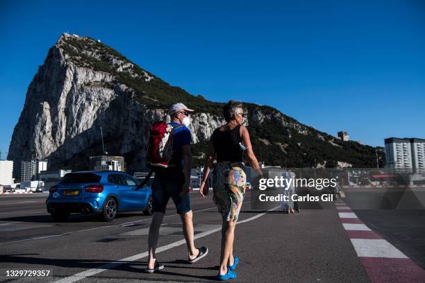 Two people walk on the entrance road to Gibraltar with the rock on the background on July 03, 2021 in Gibraltar, Gibraltar. With a population of just...