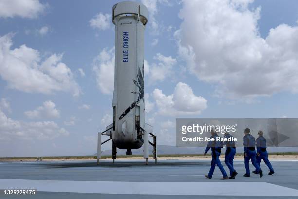 Blue Origin’s New Shepard crew Jeff Bezos, Wally Funk, Oliver Daemen, and Mark Bezos walk near the booster to pose for a picture after flying into...