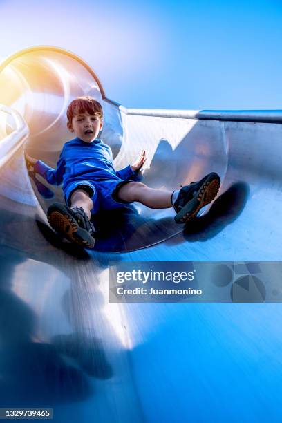 kaukasischer kleiner junge spielt auf dem spielplatz in der rutsche - screaming man looking up stock-fotos und bilder