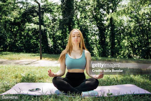 beautiful young girl meditating in nature - lotus position imagens e fotografias de stock