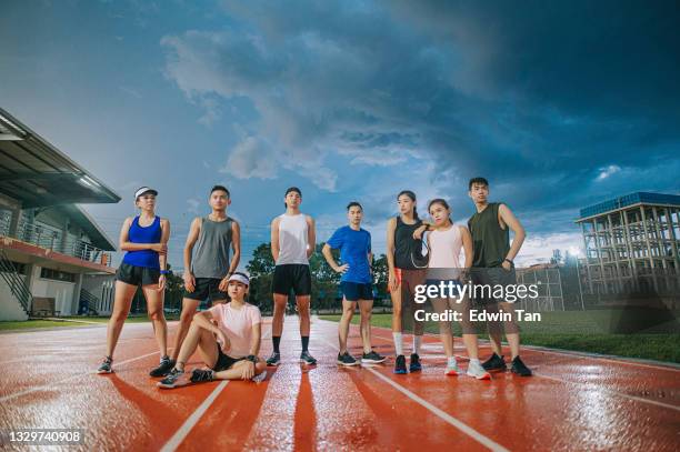 asiatische chinesische sportmannschaft athlet coole einstellung blickt am späten abend auf das leichtathletikstadion - mixed age range stock-fotos und bilder