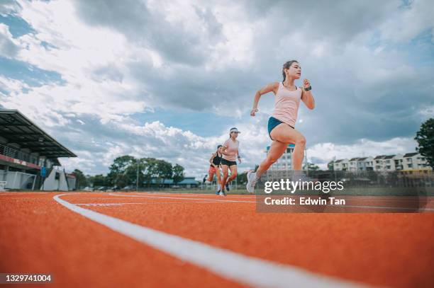 asian chinese female athletes running at track rainy late evening in stadium - short track imagens e fotografias de stock