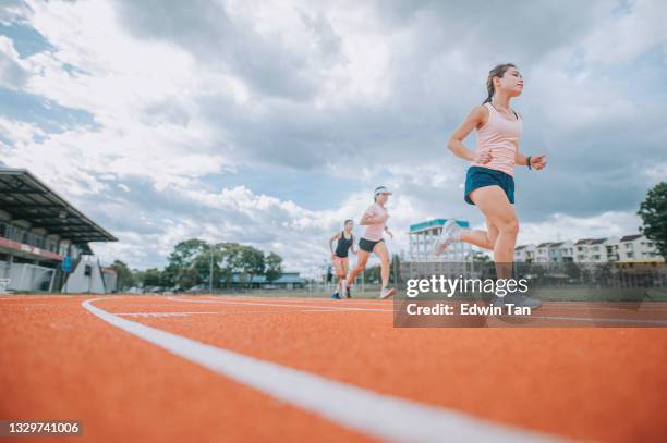 asian chinese female athletes running at track rainy late evening in stadium - short track imagens e fotografias de stock