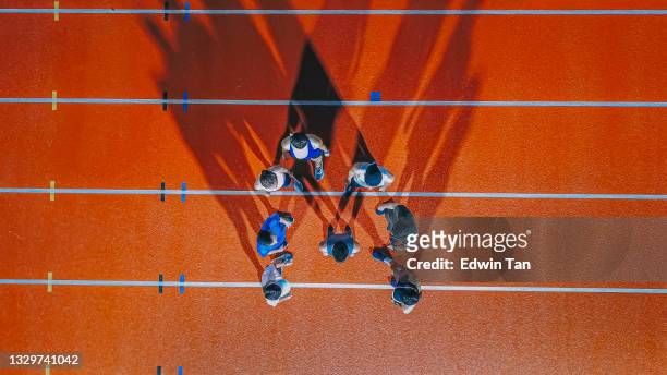 directly below drone point of view asian chinese athletes and captain lining up at track and field stadium at night - mixed bildbanksfoton och bilder