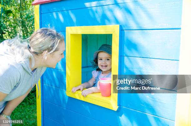 little girl and wooden toy house - casa de brinquedo imagens e fotografias de stock