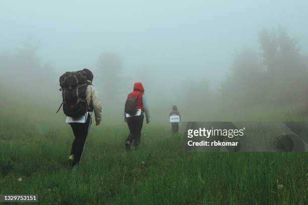 family hiking with child with backpacks in foggy forest - fog camper stock pictures, royalty-free photos & images