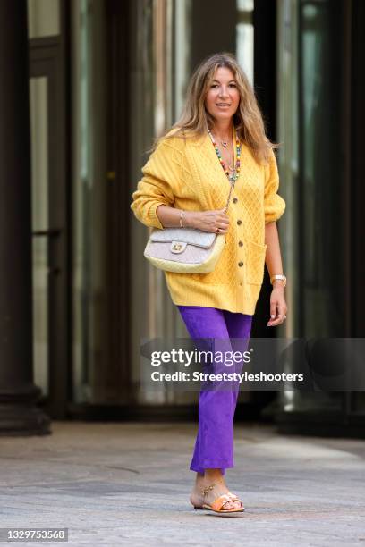 Yasmin von Schlieffen-Nannen wearing a yellow knitted cashmere cardigan by Uzwei, purple leather pants by Stouls, a white and pastel yellow colored...