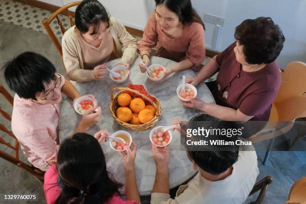 family eating glutinous rice balls (tangyuan) together - winterzonnewende stockfoto's en -beelden