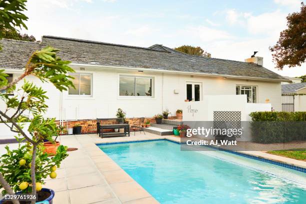 swimming pool and patio in the backyard of a contemporary home - backyard no people stock pictures, royalty-free photos & images