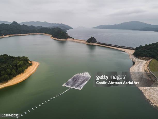 aerial view showing solar panels floating in plover cove reservoir, new territories, hong kong - zonne eiland stockfoto's en -beelden