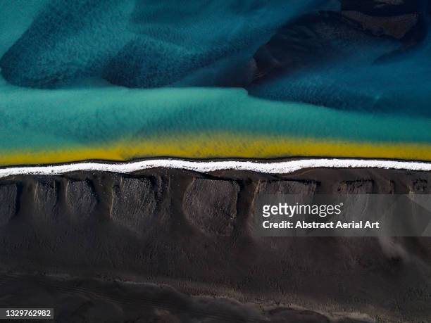 drone shot showing a black sand beach at the edge of braided river, iceland - beach bird's eye perspective imagens e fotografias de stock