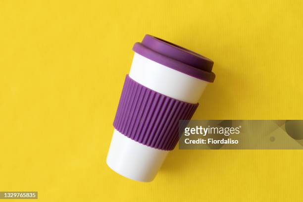bamboo reusable hot drink cup with purple silicone lid on yellow background - reusable coffee cup stock pictures, royalty-free photos & images
