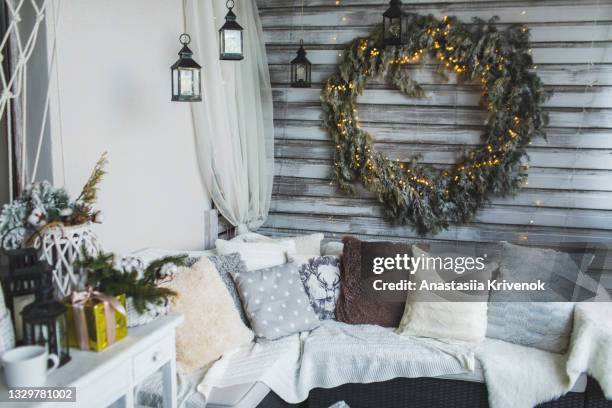 sofa with knit blankets and cushions on home cozy terrace with christmas decoration. - pracht tanne stock-fotos und bilder
