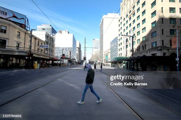 Man walks across a empty King William Street in the centre of Adelaide's CBD on July 21, 2021 in Adelaide, Australia. South Australia is in lockdown...