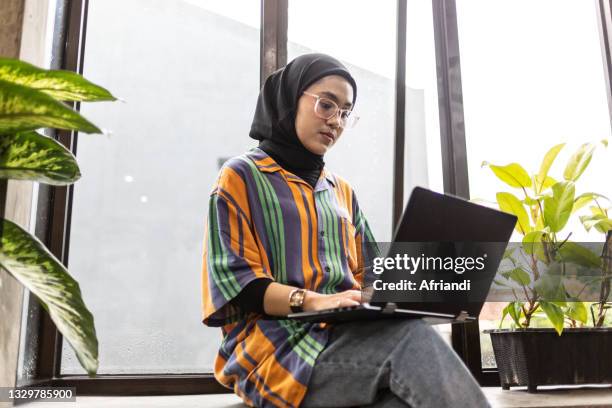 young professional woman working in a co-working space - java stockfoto's en -beelden