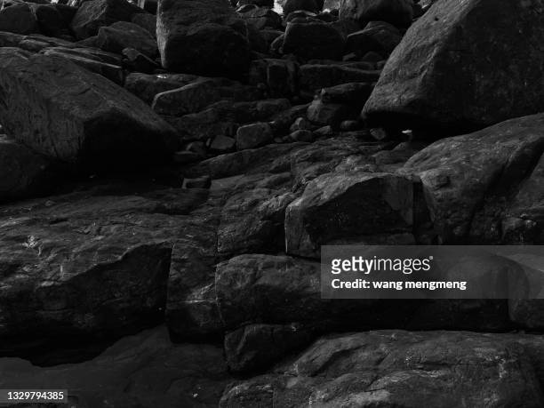 a black stony beach by the sea - piedra fotografías e imágenes de stock