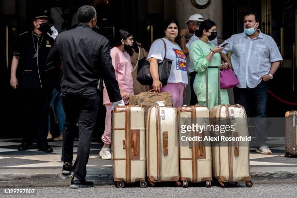 Bellhop waits with luggage as tourists are seen the Plaza Hotel on July 20, 2021 in New York City. New York City has seen a slow increase of tourism...