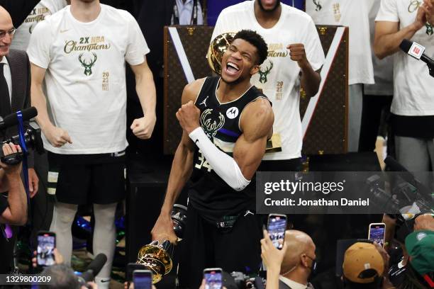 Giannis Antetokounmpo of the Milwaukee Bucks celebrates winning the Bill Russell NBA Finals MVP Award after defeating the Phoenix Suns in Game Six to...