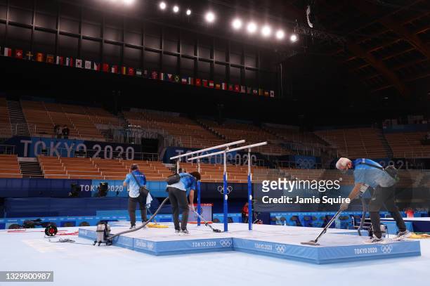 Olympic volunteers clean the venue during Men's Podium Training ahead of the Tokyo 2020 Olympic Games at Ariake Gymnastics Centre on July 21, 2021 in...