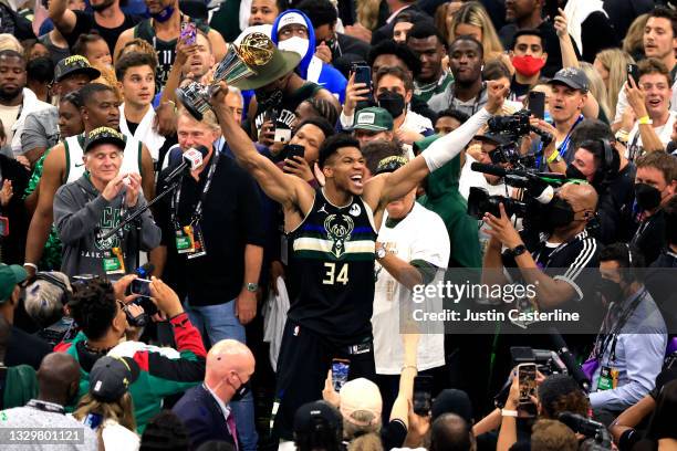 Giannis Antetokounmpo of the Milwaukee Bucks celebrates winning the Bill Russell NBA Finals MVP Award after defeating the Phoenix Suns in Game Six to...