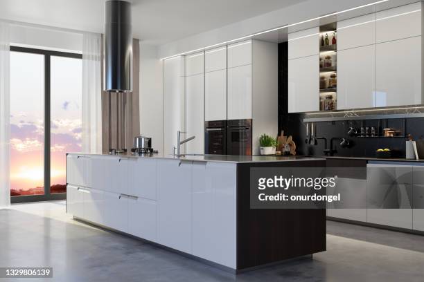 luxury kitchen interior with island, white cabinets, kitchen utensils and sunset view from the window. - kookeiland stockfoto's en -beelden