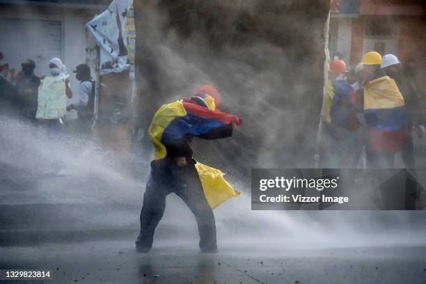 Member of the front line tries to resist the jet of water from a tank during the riots between protesters and members of the ESMAD of the police in...