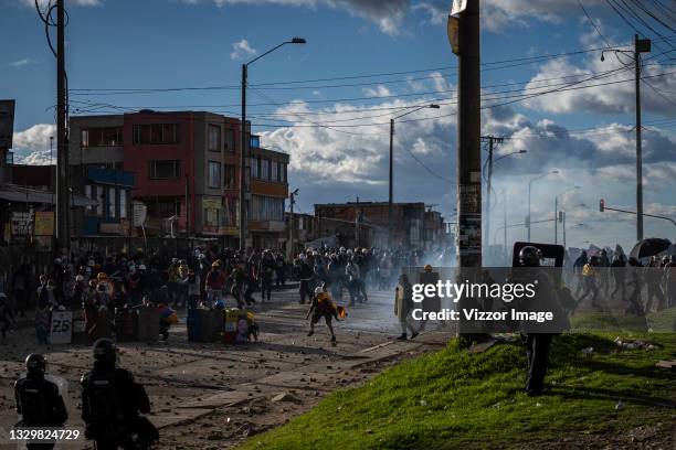 Front-line protesters and ESMAD police clash in the Usme sector during the riots on July 20, 2021 in Bogota, Colombia. Delegates of the National...