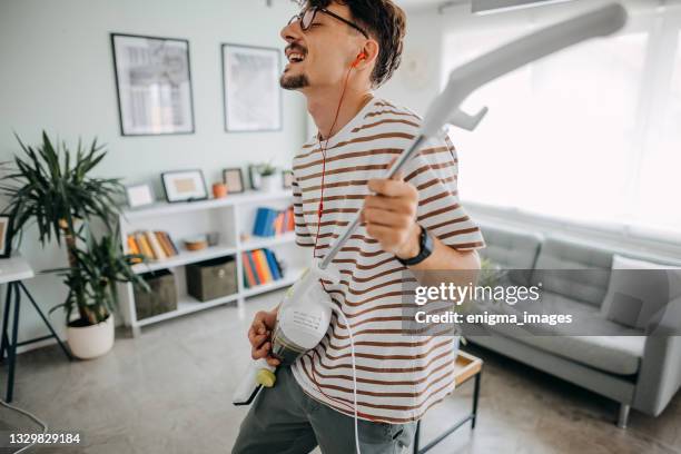 young man cleaning house - housework humour stock pictures, royalty-free photos & images