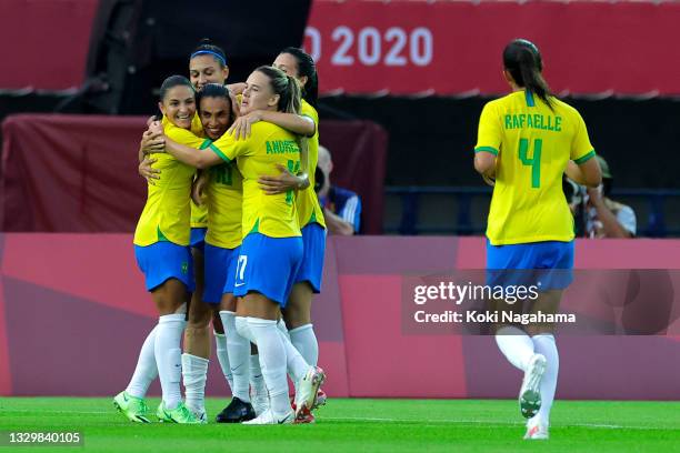 Marta of Team Brazil celebrates with teammates Debinha and Andressinha after scoring their side's third goal during the Women's First Round Group F...