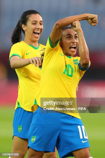Marta of Team Brazil celebrates with teammate Julia after scoring their side's third goal during the Women's First Round Group F match between China...