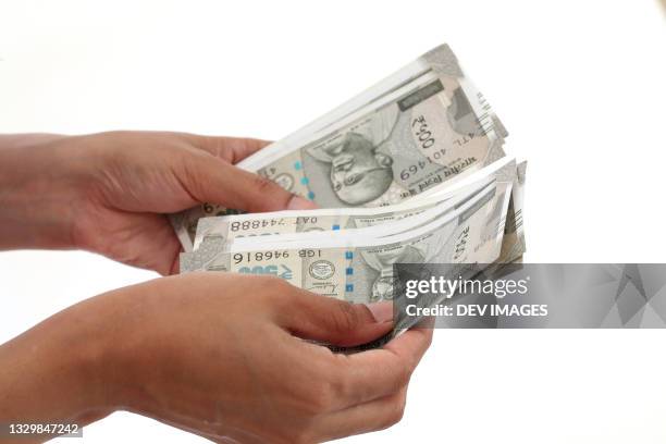 counting indian currency notes against white - rupee stock pictures, royalty-free photos & images