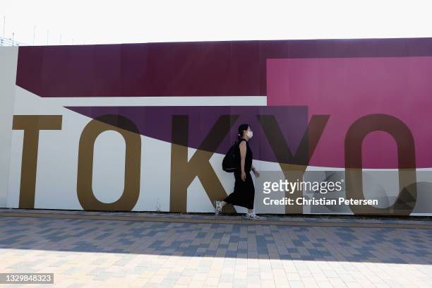 Woman walks past "Tokyo 2020" signage ahead of the Tokyo 2020 Olympic Games on July 21, 2021 in Tokyo, Japan.