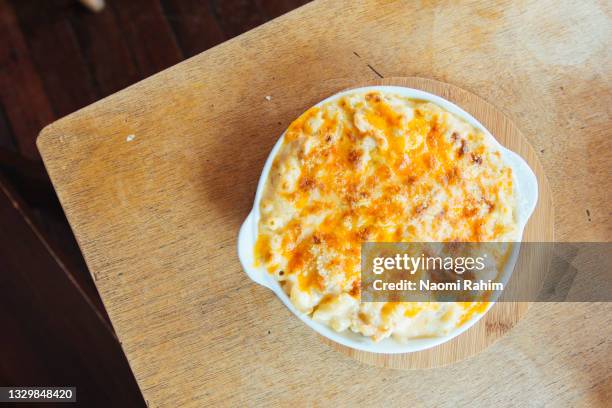 baked macaroni cheese dish on a timber table - baked goods above stock pictures, royalty-free photos & images