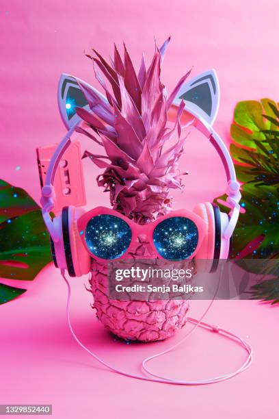 party pineapple with sunglasses and headphones - tropical music stock-fotos und bilder