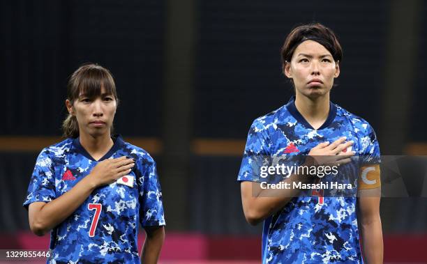 Emi Nakajima and Saki Kumagai of Team Japan stand for the national anthem prior to the Women's First Round Group E match between Japan and Canada...
