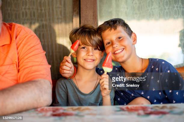 boys eating ice-cream shaped like water melon. - kid eating ice cream stockfoto's en -beelden