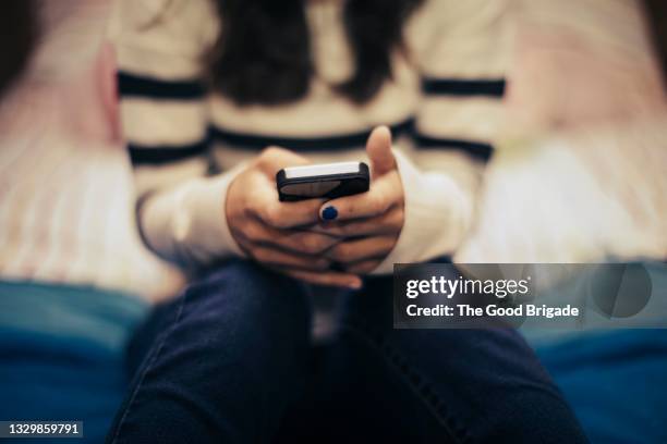 close up of teenage girl in bedroom using smart phone - adolescenza foto e immagini stock