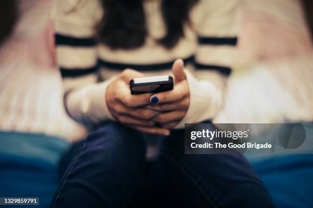 close up of teenage girl in bedroom using smart phone - text ストックフォトと画像