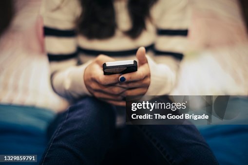 Close up of teenage girl in bedroom using smart phone Close up of teenage girl in bedroom using smart phone