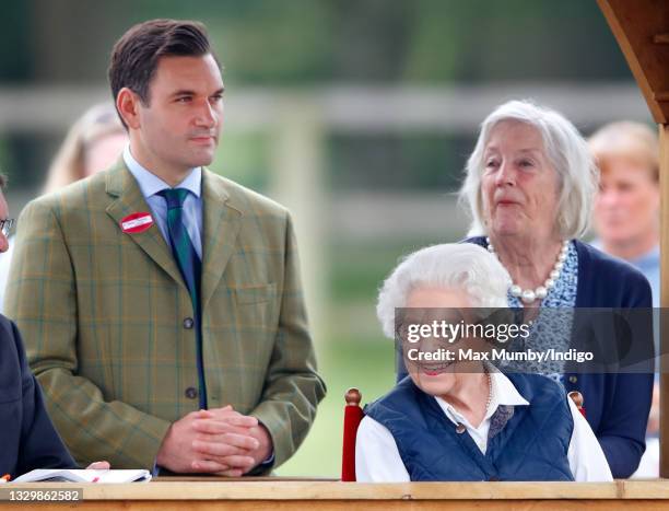 Queen Elizabeth II, accompanied by her equerry Lieutenant Colonel Tom White and her lady-in-waiting Dame Annabel Whitehead, watches her horses...
