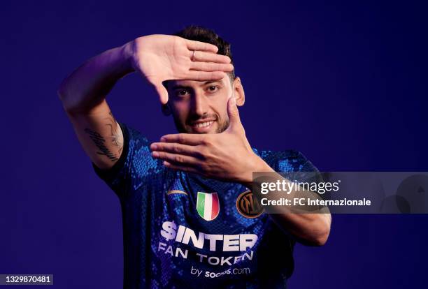 Hakan Calhanoglu of FC Internazionale poses for a portrait with the new home jersey with the main sponsor socios.com at Appiano Gentile on July 20,...