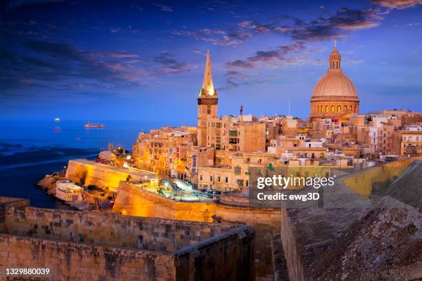 night view of valletta old town with cathedral of saint paul and marsamxett harbour, malta - maltese islands stockfoto's en -beelden