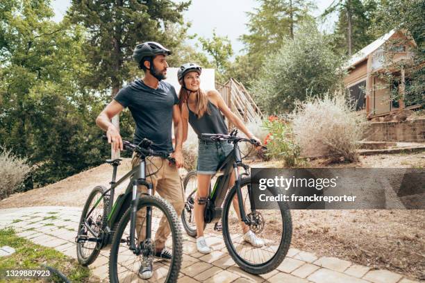 happiness couple with mountain ebike outdoors - elektrische fiets stockfoto's en -beelden