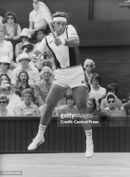 Guillermo Vilas of Argentina jumps to play a forehand return to Mark Edmondson of Australia during their Men's Singles First Round match at the...