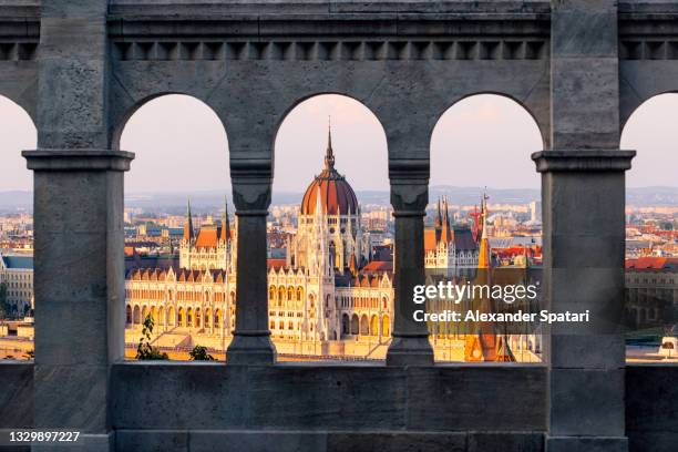 hungarian parliament seen through the arches of fisherman's bastion, budapest, hungary - budapest stock-fotos und bilder