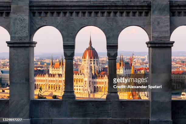 hungarian parliament seen through the arches of fisherman's bastion, budapest, hungary - budapest skyline stock pictures, royalty-free photos & images
