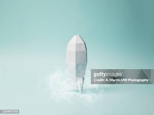 space rocket made of paper isolated on a light blue background. paper craft.  concept of space travel. space race. - restarting fotografías e imágenes de stock