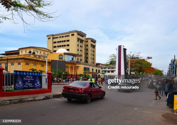 broad street - people and traffic by the executive pavilion and president william tubman monument, monrovia, liberia - monrovia liberia stock pictures, royalty-free photos & images