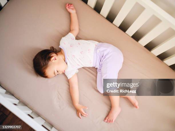 baby sleeping in a crib - baby bassinet stock pictures, royalty-free photos & images