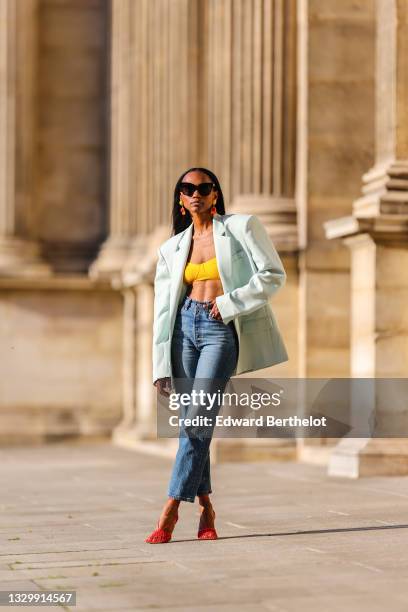 Emilie Joseph @in_fashionwetrust wears a pastel green oversized blazer jacket from The Frankie Shop, a yellow bralette / bra / bikini top, high...